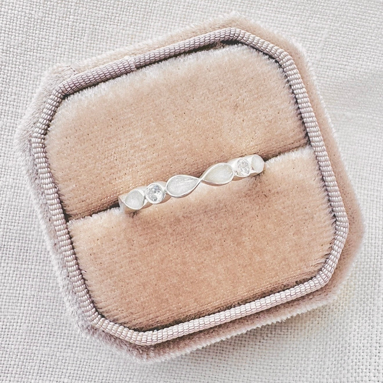 Cherish Infinity sterling silver breastmilk ring with pear-shaped breastmilk settings and sparkling stones.