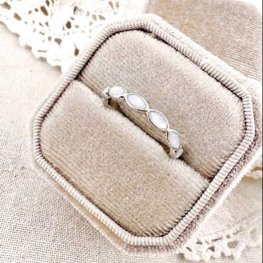 Marquise Half Band breastmilk ring in sterling silver with white breastmilk inclusions, displayed in a neutral velvet ring box.