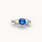 Silver ring with a blue ashes memorial gemstone on a white background