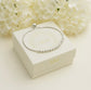 Silver bracelet on a white Memory Within jewelry box, against a soft floral background.