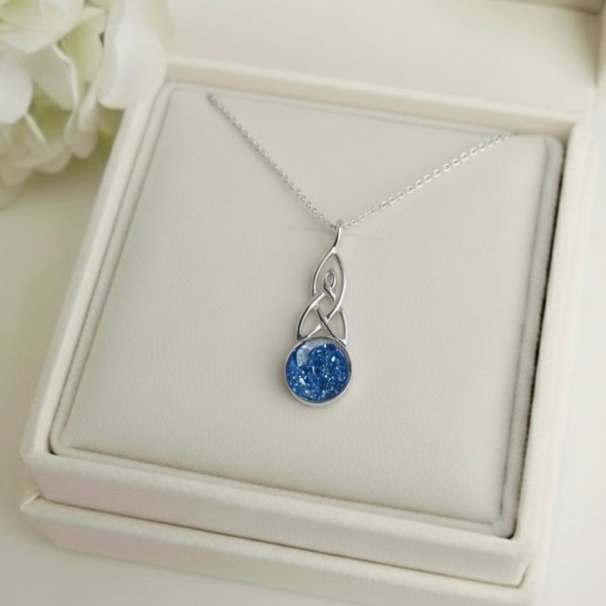 Silver necklace with a blue celtic ashes keepsake pendant on a white memory within jewelry box