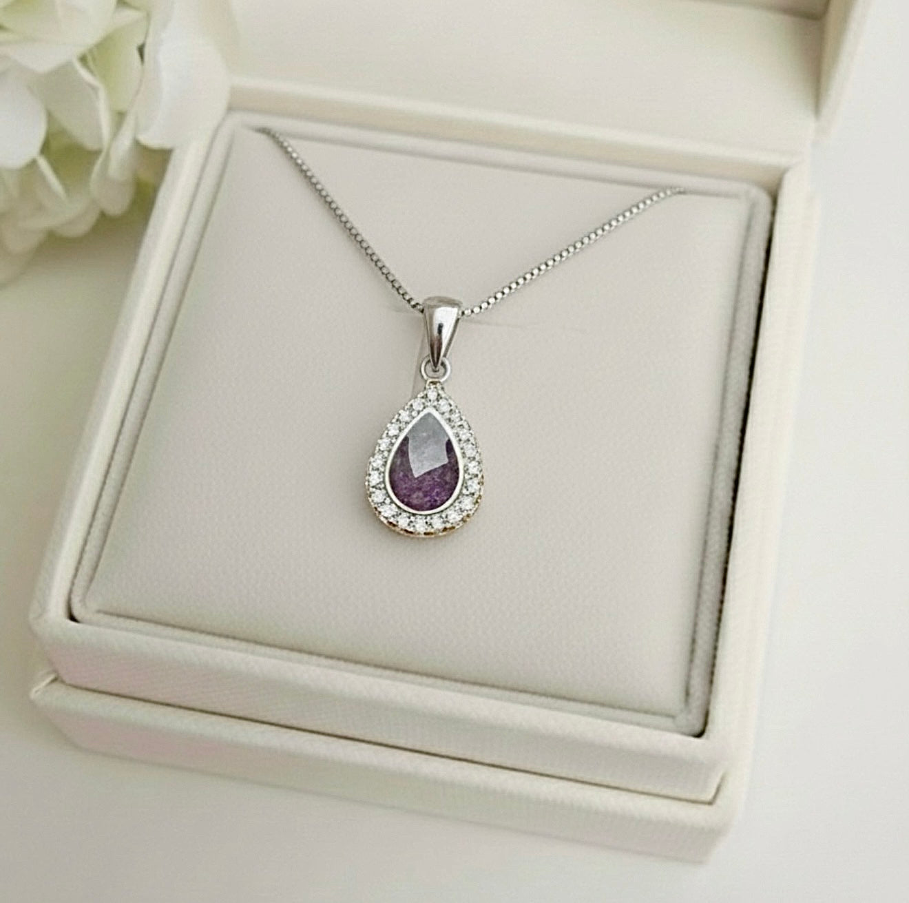 Silver teardrop memorial pendant with purple gemstone on a white Memory Within jewelry box