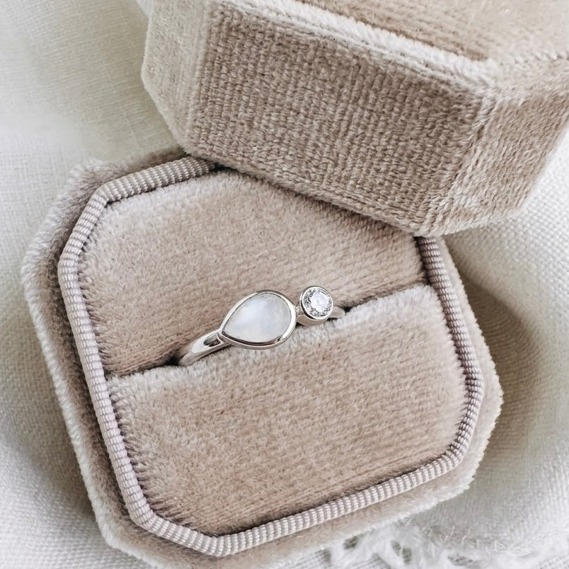 Embrace Drop Breastmilk Ring with teardrop breastmilk stone and round sparkling accent stone in sterling silver.