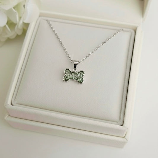 Silver necklace with a dog bone ashes keepsake pendant on a white memory within jewelry box