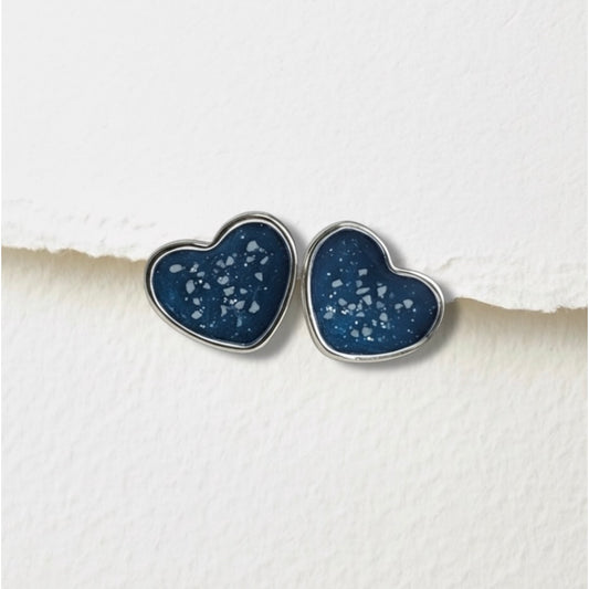 Heart-shaped blue ashes keepsake earrings on a textured white surface
