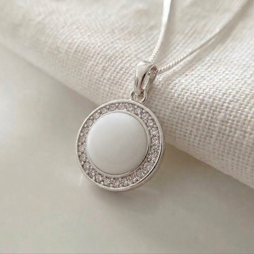 Luna Halo breastmilk pendant in sterling silver with round breastmilk centre and cubic zirconia halo.