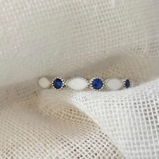 Marquise Gem Halfband breastmilk ring with alternating white breastmilk stones and blue round gemstones.