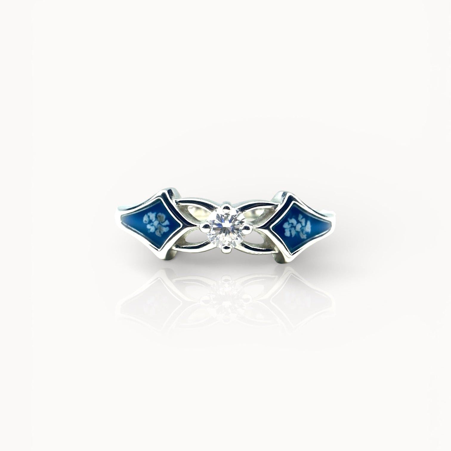 Silver ring with ashes and blue resin on a white background